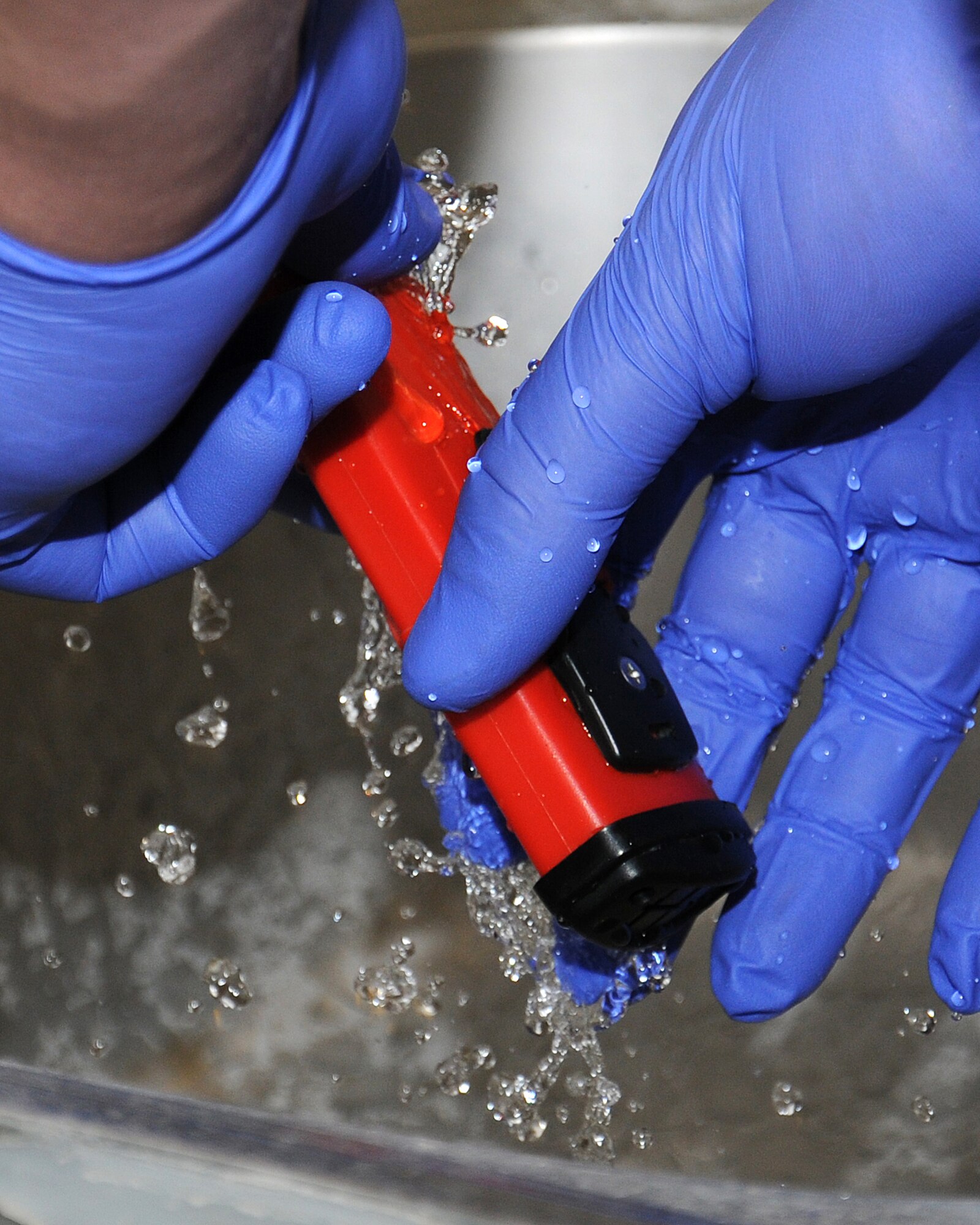 An Airman from the 100th Civil Engineer Squadron Water and Wastewater Plant shows Chief Master Sgt. Tracy Jones, 100th Air Refueling Wing command chief, how to test a sample of water for pH levels prior to it being released back into the environment June 6, 2013, at RAF Mildenhall, England. Water plant personnel showed Jones how they do their part in the mission as part of a “dirty jobs” program. (U.S. Air Force photo by Gina Randall/Released)