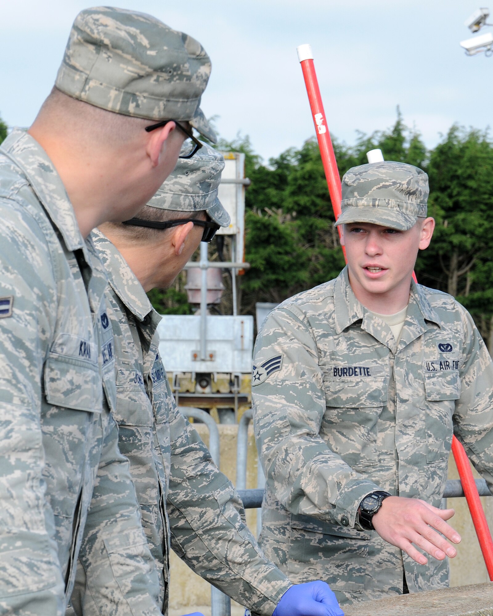 From right, Senior Airman Andrew Burdette, 100th Civil Engineer Squadron Water and Fuels Maintenance journeyman from Victorville, Calif., discusses how to scrub the primary clarifier with Chief Master Sgt. Tracy Jones, 100th Air Refueling Wing command chief, and Airman 1st Class Justin Krah, 100th CES Water and Wastewater Plant operator from Shamokin, Pa., June 6, 2013, at RAF Mildenhall, England. The command chief took part in the “dirty jobs” program where water plant personnel showed him how they carry out their mission. (U.S. Air Force photo by Gina Randall/Released)
