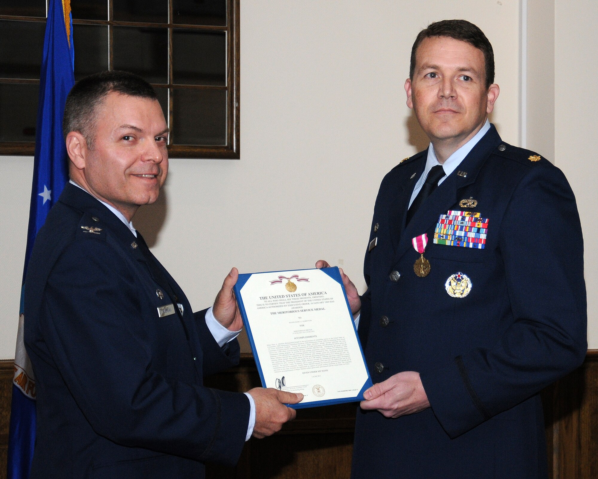 From left, Col. Joseph Rushlau, 100th Maintenance Group commander, awards Maj. Marc Albritton, 100th Maintenance Operations Squadron commander, the Meritorious Service Medal during an inactivation ceremony June 3, 2013, at RAF Mildenhall, England. The 100th MOS provided administrative and technical support for the group and deployed to support refueling operations worldwide. (U.S. Air Force photo by Gina Randall/Released)