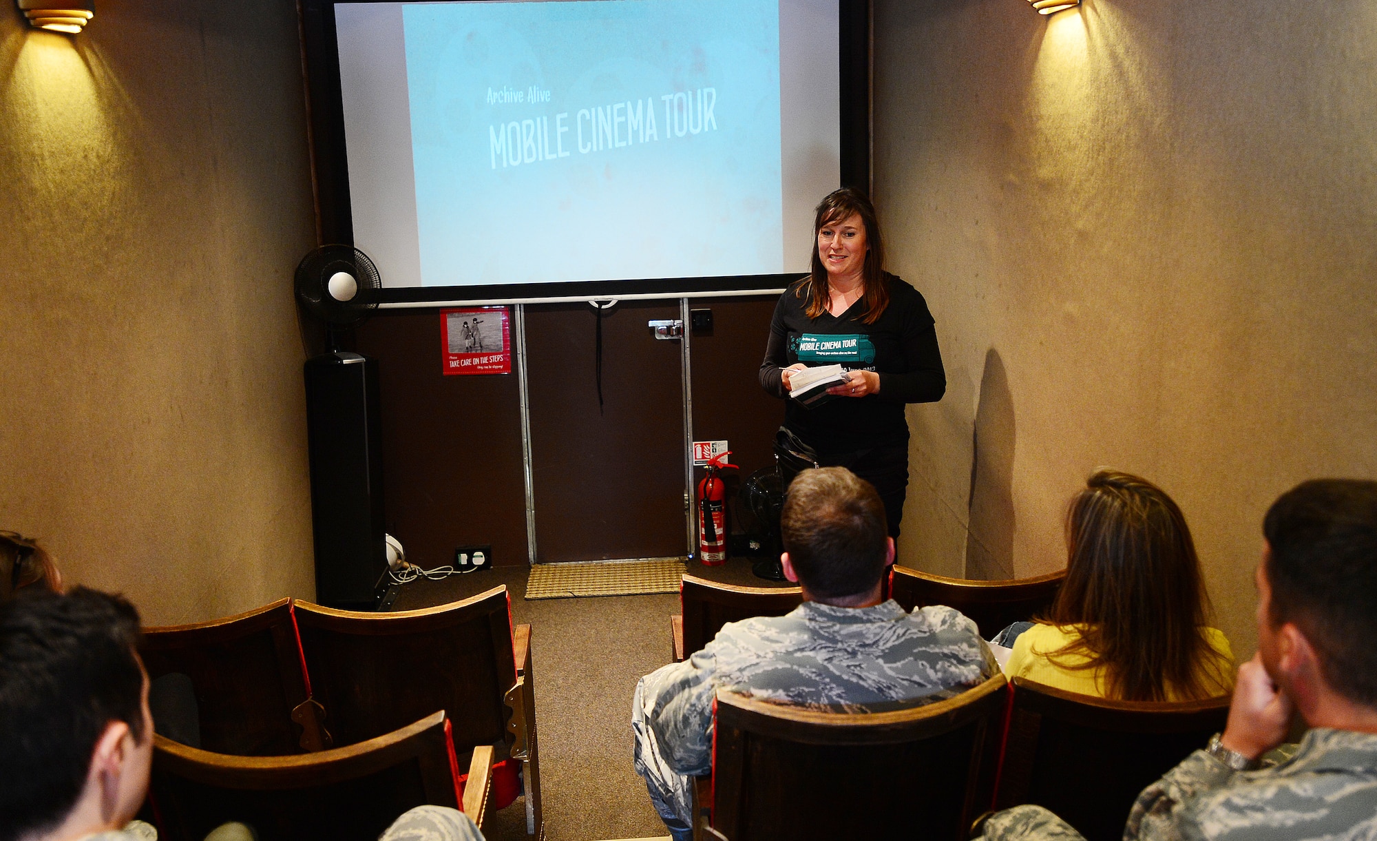 ROYAL AIR FORCE LAKENHEATH, England – Lindsey Roffe, Digital Heritage Project communications manager of Norwich Heritage Economic and Regeneration Trust, welcomes Liberty Wing members aboard a 1967 mobile cinema bus at the Base Exchange June 5, 2013. Roffe and her crew came to give the base populace an opportunity to see East Anglia footage from the 1940s shot by U.S. Army Air Force Airmen. (U.S. Air Force photo by Senior Airman Tiffany M. Grigg) 