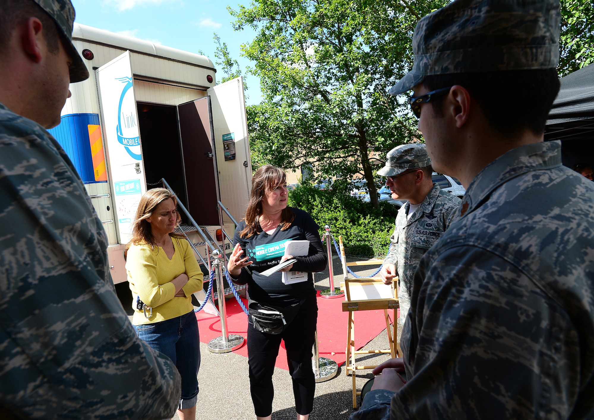 ROYAL AIR FORCE LAKENHEATH, England – Lindsey Roffe, Digital Heritage Project communications manager of Norwich Heritage Economic and Regeneration Trust (center), provides information on the Mobile Cinema Tour to Col. Mark Ciero, 48th Fighter Wing vice commander (right center),  and others prior to boarding a 1967 mobile cinema bus at the Base Exchange June 5, 2013. Roffe and her crew brought the cinema bus to give the base populace an opportunity to see East Anglia footage from the 1940s shot by U.S. Army Air Force Airmen. (U.S. Air Force photo by Senior Airman Tiffany M. Grigg) 