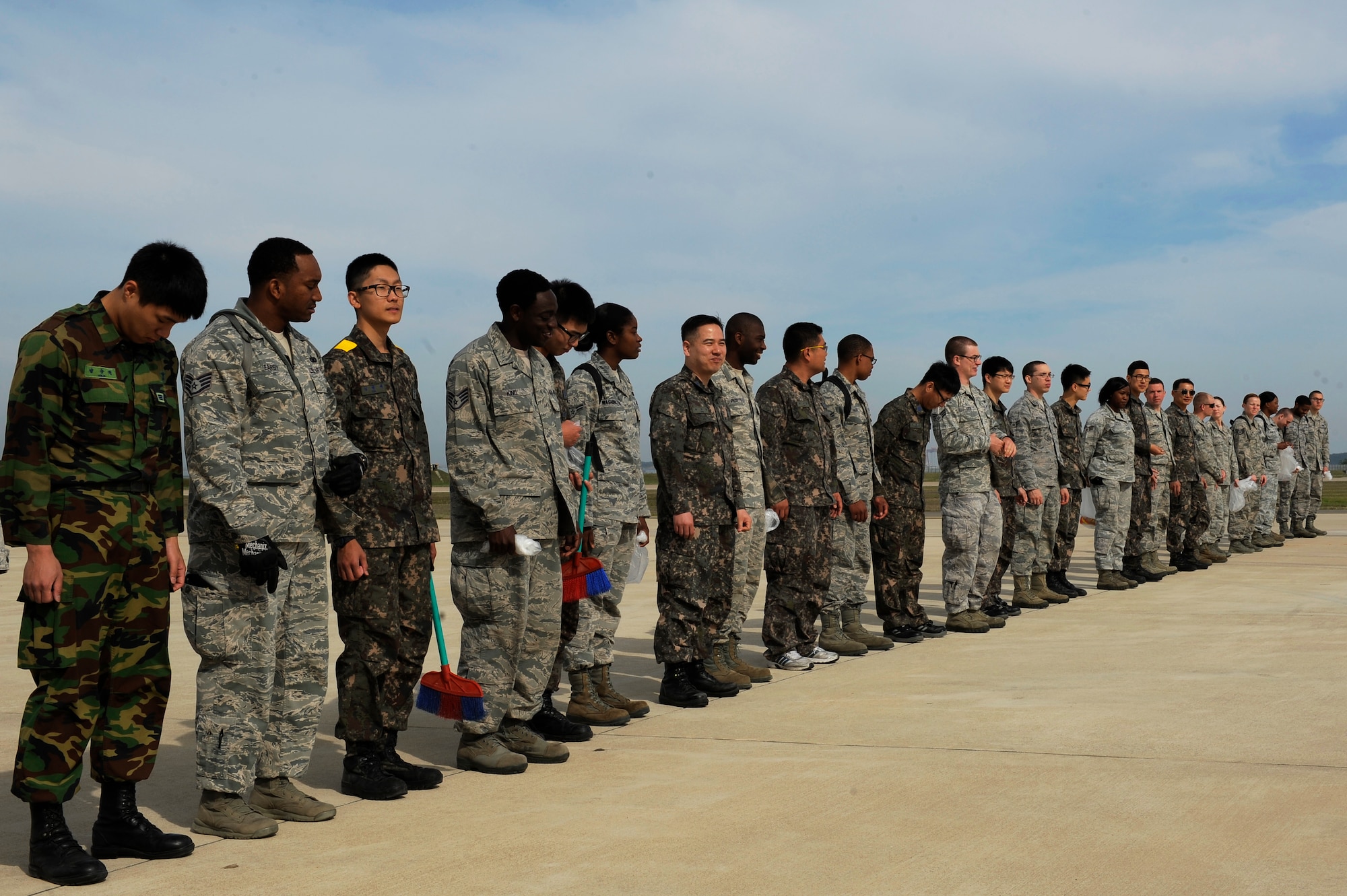 Airmen from the 8th Fighter Wing and Republic of Korea air force, 38th Fighter Group line up for a Foreign Object Debris walk across the flight line at Kunsan Air Base, Republic of Korea, May 17, 2013. The Airmen walked the entire flight line, and cleaned it of rocks and debris. (U.S. Air Force photo by Senior Airman Marcus Morris/Released)