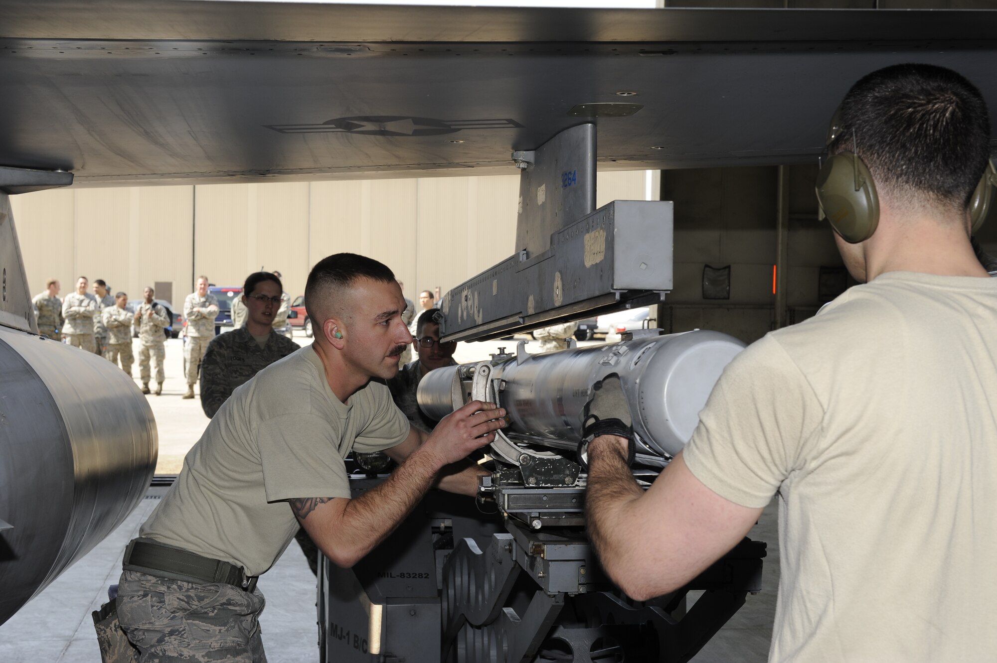 Staff Sgt. Gregory Harrison, left, and Airman 1st Class Jonathan Mahlan, 8th Aircraft Maintenance Squadron, 35th Aircraft Maintenance Unit weapons load crew members attach an AIM-120 Advanced Medium-Range Air-to-Air Missile onto an F-16 Fighting Falcon at Kunsan Air Base, Republic of Korea, March 29, 2013. This was the first weapons loading competition of the quarter between the 8th AMXS' 35th and 80th AMU, and the 4th Expeditionary Aircraft Maintenance Unit, Hill Air Force Base, Utah. (U.S. Air Force photo by Senior Airman Marcus Morris/Released)