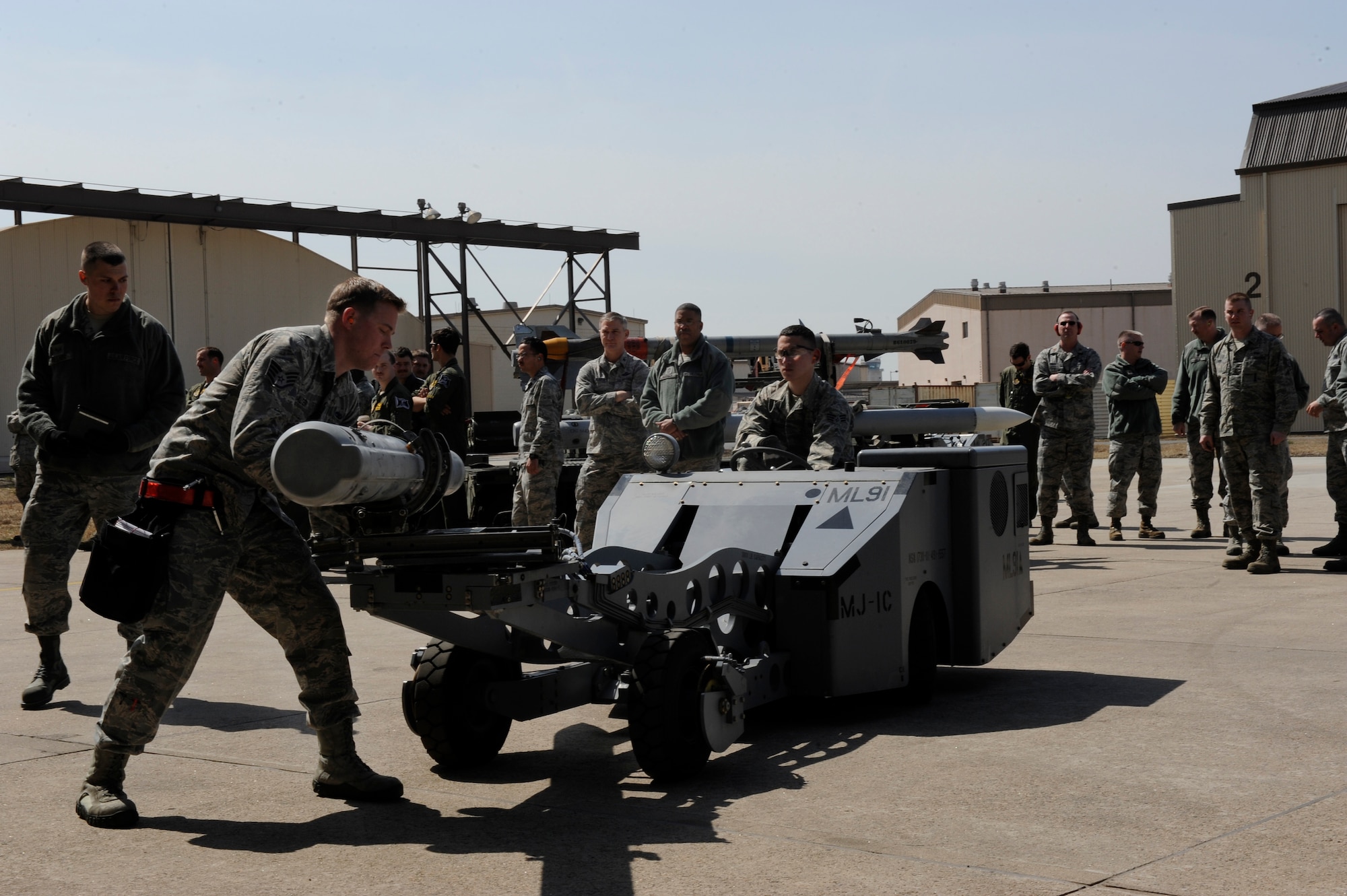 Staff Sgt. Christopher Alteri, 4th Expeditionary Aircraft Maintenance Unit, Hill Air Force Base, Utah guides one of five AIM-120 Advanced Medium-Range Air-to-Air Missile as Senior Airman Daniel Repreza, 4th EAMU, drives a bomb loader to an F-16 Fighting Falcon during a weapons loading competition against the 8th Aircraft Maintenance Squadron’s 35th and 80th AMU at Kunsan Air Base, Republic of Korea, March 29, 2013. The 35th AMU took first place in the competition with the highest total score. (U.S. Air Force photo by Senior Airman Marcus Morris/Released) 