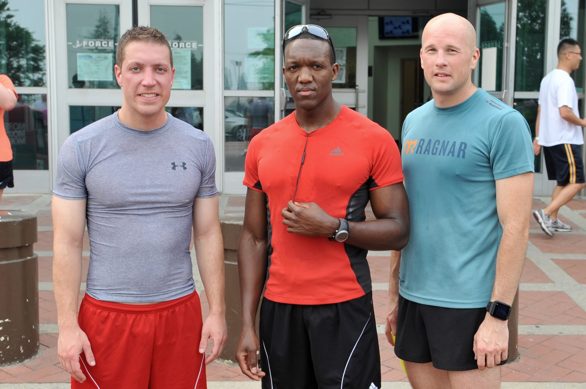 Capt. John Reid, 7th Air Force assistant staff judge advocate, Senior Airman Moses Tum, 7th AF budget analyst, and Chief Master Sgt. Mike Hullender, 51st Logistics Readiness Squadron vehicle fleet manager, come together to take a photo after being the first three to complete the Medal of Honor Recipient 5K run at Osan Air Base, Republic of Korea, June 6, 2013. Forty-five participants took part in the 5K. (U.S. Air Force/Tech. Sgt. Raymond Mills) 