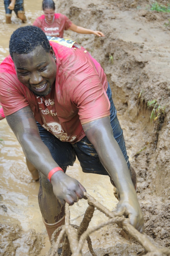 Uchenna Faumuina-Eza, of Woodbridge, Va., drags himself through the mud crawl during the Marine Corps Marathon's Run Amuck on June 8, 2013. More than 3,000 people participated in the 3.5-mile race around Marine Corps Base Quantico, though the woods, over the hills and into often neck-deep mud pits.