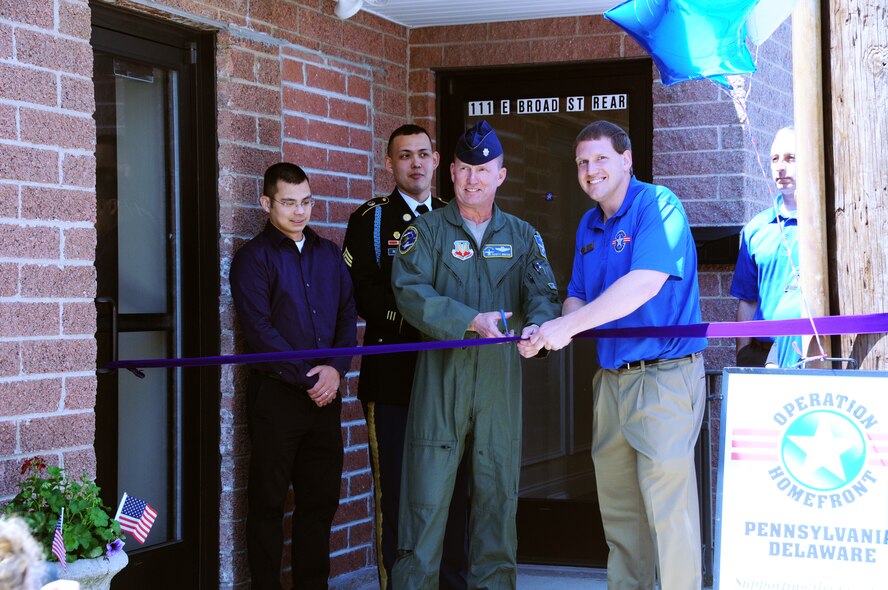 Lt. Col. Scott Hreso, wing safety officer for the 111th Fighter Wing and Operation Homefront manager, Pete Stinson get ready to cut the ribbon on their new facility Souderton, Pa. on April 25. Operation Homefront is an organization dedicated to supporting military member and their families by providing a broad spectrum of items including food, clothing and back-to-school supplies. This new building offers a much needed transportation dock for loading trucks and plenty of storage space said Stinson. 