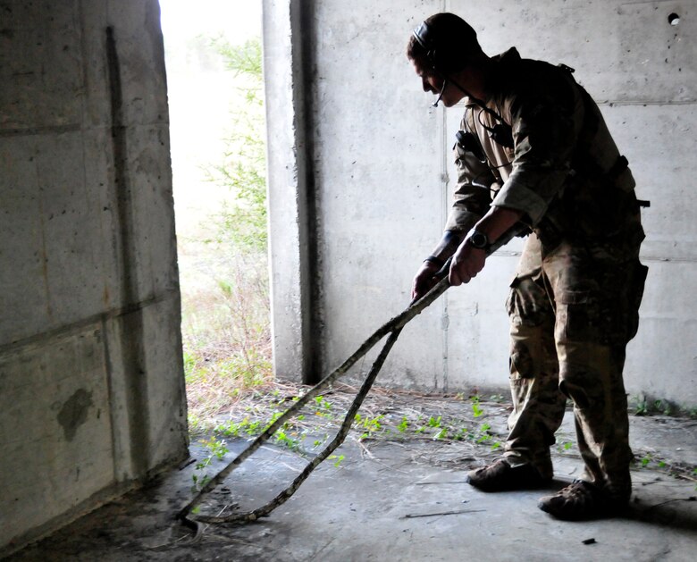 A 23rd Special Tactics Training Squadron instructor removes a snake from the building prior to an exercise on the Eglin Air Force Base range.  The counter-insurgency exercise provided critical training in tactics, land navigation and mission planning to potential Air Force combat controllers.  (U.S. Air Force photo/Tech. Sgt. Cheryl Foster)