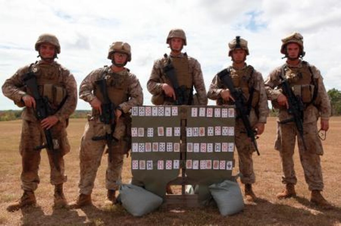(from left to right) Pfc. Justin Oates, Pfc. Joshua Crawford, Lance Cpl. Jeff Doherty, Lance Cpl. Jeremy Coulon and Lance Cpl. Brendan Young, all with Weapons Platoon, Lima Company, 3rd Battalion, 3rd Marine Regiment, Marine Rotational Force – Darwin, pose next to their target made out of playing cards after winning a poker-shoot competition, here, May 16. These Marines shot the best poker hands throughout the competition.
