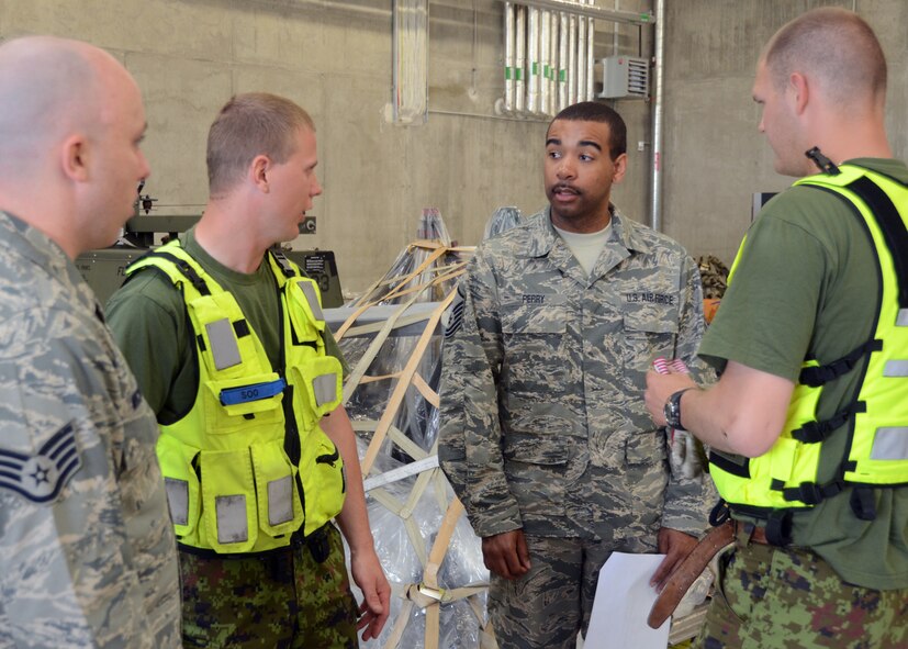 U.S. Air Force Master Sgt. Dallas Perry, 175th Logistics Readiness Squadron, Maryland Air National Guard, works with Airmen in the Estonian Air Force to load equipment at Amari Air Base, Estonia on June 7, 2013, during Saber Strike.  Saber Strike 2013 is a multinational exercise involving approximately 2,000 personnel from 14 countries and is designed to improve NATO interoperability and strengthen the relationships between military forces of the U.S., Estonia and other participating nations. (U.S. Air National Guard photo by Staff Sgt. Benjamin Hughes)