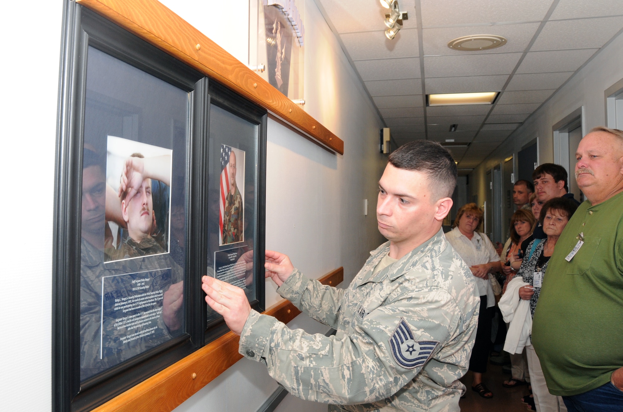 Tech. Sgt. Raymond Oakley places retired Tech. Sgt. Phillip Myers’ plaque into the Hall of Honor. Sergeant Myers received two Purple Heart Medals as a result of his 2004 deployment to Iraq where he sustained injuries from two different improvised explosive device detonations. (U.S. Air National Guard photo by Senior Airman Claire Behney/Released)