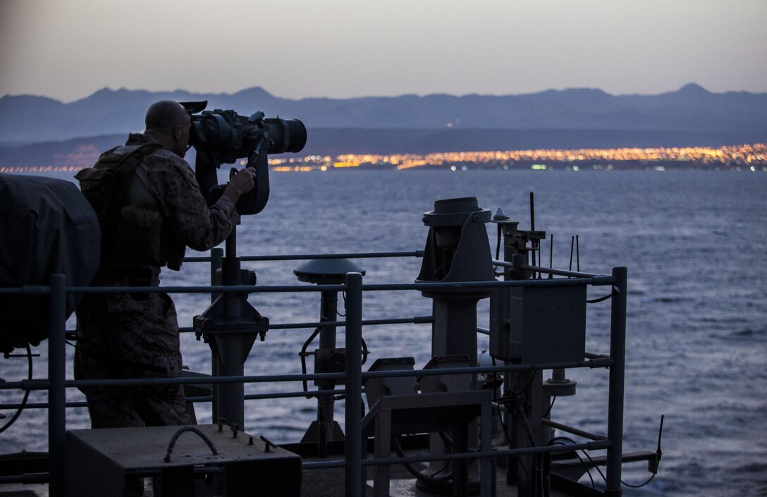 A U.S. Marine assigned to 26th Marine Expeditionary Unit (MEU), utilizes an observational optic to provide security aboard the USS Kearsarge (LHD 3) as it transits the Straits of Tiran towards Jordan, June 6, 2013. The 26th Marine Expeditionary Unit is a Marine Air-Ground Task Force forward-deployed to the U.S. 5th Fleet area of responsibility aboard the Kearsarge Amphibious Ready Group serving as a sea-based, expeditionary crisis response force capable of conducting amphibious operations across the full range of military operations. (U.S. Marine Corps photo by Sgt. Christopher Q. Stone, 26th MEU Combat Camera/Released)