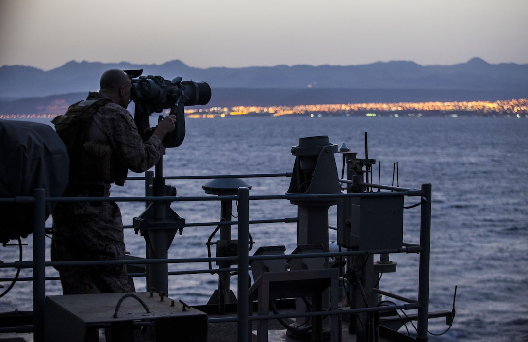 A U.S. Marine assigned to 26th Marine Expeditionary Unit (MEU), utilizes an observational optic to provide security aboard the USS Kearsarge (LHD 3) as it transits the Straits of Tiran towards Jordan, June 6, 2013. The 26th Marine Expeditionary Unit is a Marine Air-Ground Task Force forward-deployed to the U.S. 5th Fleet area of responsibility aboard the Kearsarge Amphibious Ready Group serving as a sea-based, expeditionary crisis response force capable of conducting amphibious operations across the full range of military operations. (U.S. Marine Corps photo by Sgt. Christopher Q. Stone, 26th MEU Combat Camera/Released)