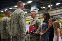 Col. Jeffrey M. Reagan (center), former chief of staff for 2nd Marine Logistics Group, is presented a folded flag and the Legion of Merit award during a retirement ceremony at 2nd Maintenance Battalion’s maintenance bay aboard Camp Lejeune, N.C., June 7, 2013. In the completion of Reagan’s retirement, he received the Piping Ashore ceremony which is reserved for service members who have completed a career serving in the highest naval traditions.