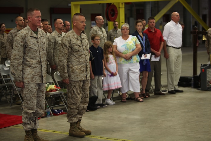 Brig. Gen. Edward D. Banta (left), the commanding general of 2nd Marine Logistics Group, and Col. Jeffrey M. Reagan (center), the former chief of staff for 2nd MLG, stand at attention during the “Marines’ Hymn” during a retirement ceremony at 2nd Maintenance Battalion’s maintenance bay aboard Camp Lejeune, N.C., June 7, 2013. Reagan’s family, friends and fellow Marines supported him as he stood by his commanding general for the final time during the playing of “Anchors Aweigh” and the “Marines’ Hymn.” 