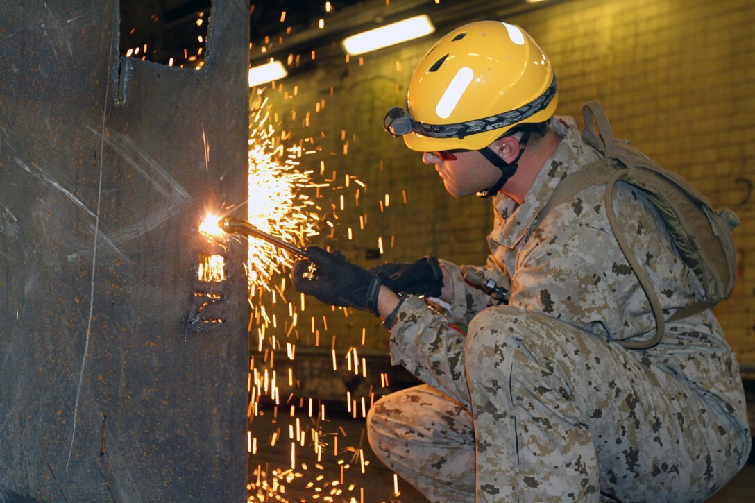 Petty Officer 2nd Class Ty Stricklin, 22nd Marine Expeditionary Unit corpsman and native of Hurricane, W.V., practices cutting through steel sheets with a blow torch during collapsed-structure rescue training at the Center for National Response in Gallagher, W.V., May 29, 2013. Stricklin and 10 22nd MEU Marines completed the 10-day course, which also covered rope rescues and rescue tactics in confined spaces, May 30 in preparation for the unit’s deployment early next year. (Marine Corps photo by Lance Cpl. Krista James/released)