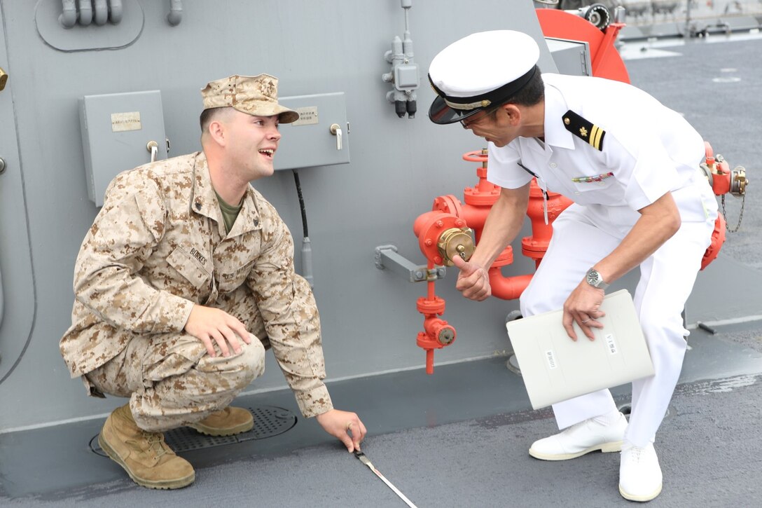 A U.S. Marine and Japanese sailor plan for an MV-22B Osprey landing aboard a Japanese Ship for Dawn Blitz 2013, occurring June 11-28 at Naval Base San Diego June 6. Dawn Blitz 2013 is a multinational amphibious exercise that promotes interoperability between the Navy and Marine Corps and coalition partners, June 11-28. Participating countries include Canada, Japan, New Zealand and military observers from seven countries.