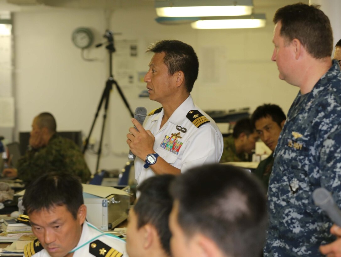 Cdr. Kiyoshi Asano, Japanese Maritime Self Defense Force Ops Staff CCF2, discusses staff planning with members of the Japanese Self Defense Force on board the Japanese ship Hyuga at Naval Base San Diego June 6.  The planning exericse gave Marines and sailors a chance share how U.S. ground components and maritime components work together to conduct amphibious operations.  This training is part of Exercise Dawn Blitz, which is scenario-driven exercise that refocuses Navy and Marine Corps and coalition forces in their ability to conduct complex ambibious operations. (Photo by: U.S. Marine Corps Staff Sgt. Jimmy H. Bention, Jr., Public Affairs Chief, 11TH Marine Expeditionary Unit)