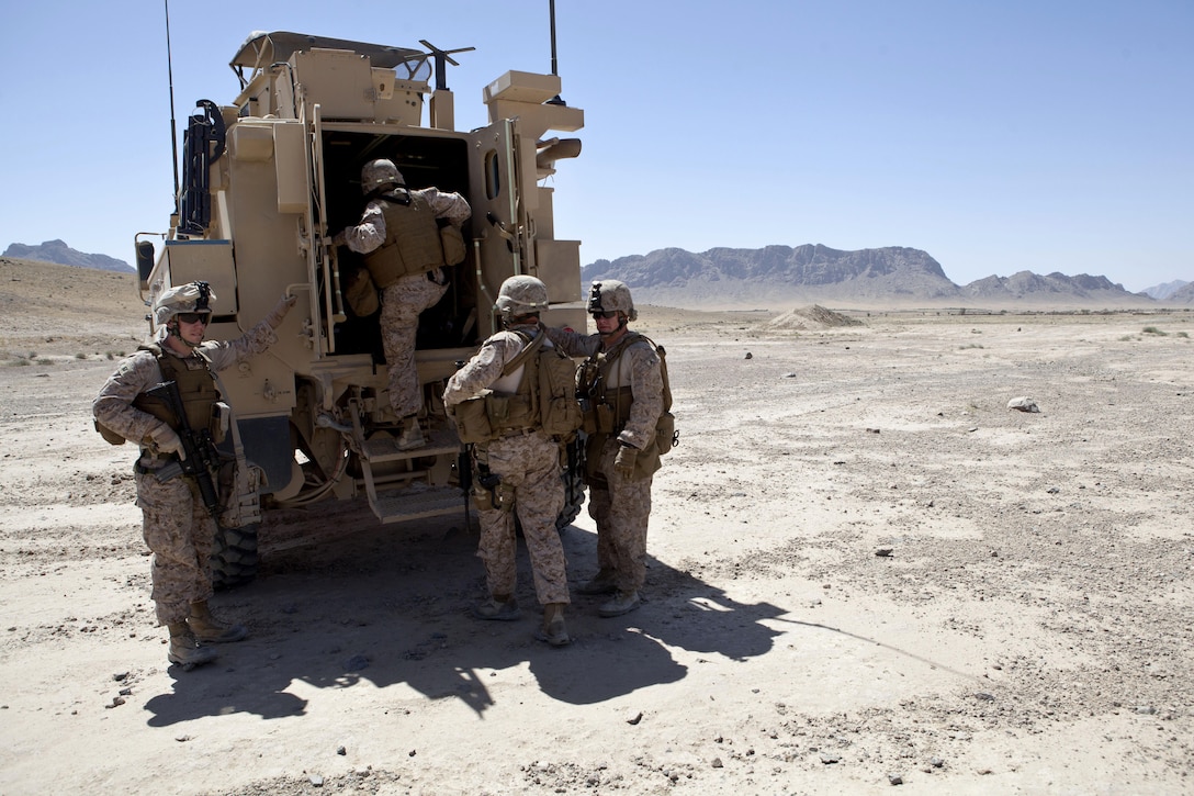 U.S. Marines with Regional Command (Southwest) and 3rd Battalion, 4th Marines, climb into a mine-resistant, ambush protected vehicle outside Forward Operating Base (FOB) Now Zad, Helmand province, Afghanistan, June 8, 2013. Maj. Gen. Walter L. Miller Jr., commanding general of Regional Command (Southwest), visited troops at FOBs Now Zad and Ereovi. (U.S. Marine Corps photo by Staff Sgt. Neill A. Sevelius/Released)