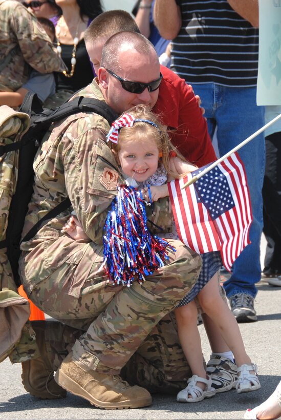 A California Air National Guardsman from the 129th Rescue Wing, Moffett Federal Airfield, Calif., is greeted by his son and daughter after returning home from a four-month deployment to Afghanistan and Horn of Africa, June 10, 2013.  Aircrew members, maintainers and support personnel from the 129th provided combat search and rescue support to Combined Joint Task Force-Horn of Africa and Operation Enduring Freedom in Afghanistan. (U.S. California Air National Guard photo by Tech. Sgt. Ray Aquino)