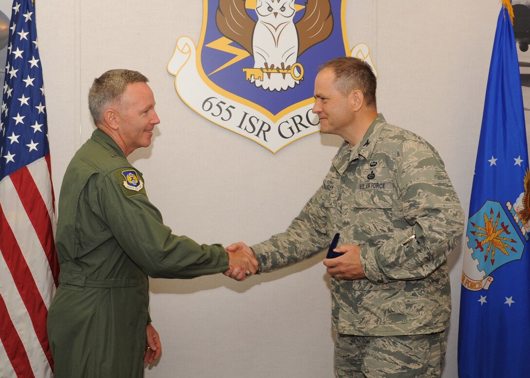 Col. Douglas Drakeley, 655th ISR Group commander, presents Maj. Gen. Bill Binger, 10th Air Force commander, with the first 655th ISR Group coin. The general was here recently and toured the group giving members coins and even a set of well-deserved Master Sgt. stripes. (U.S. Air Force photo/Staff Sgt. Veronica A. Pierce)