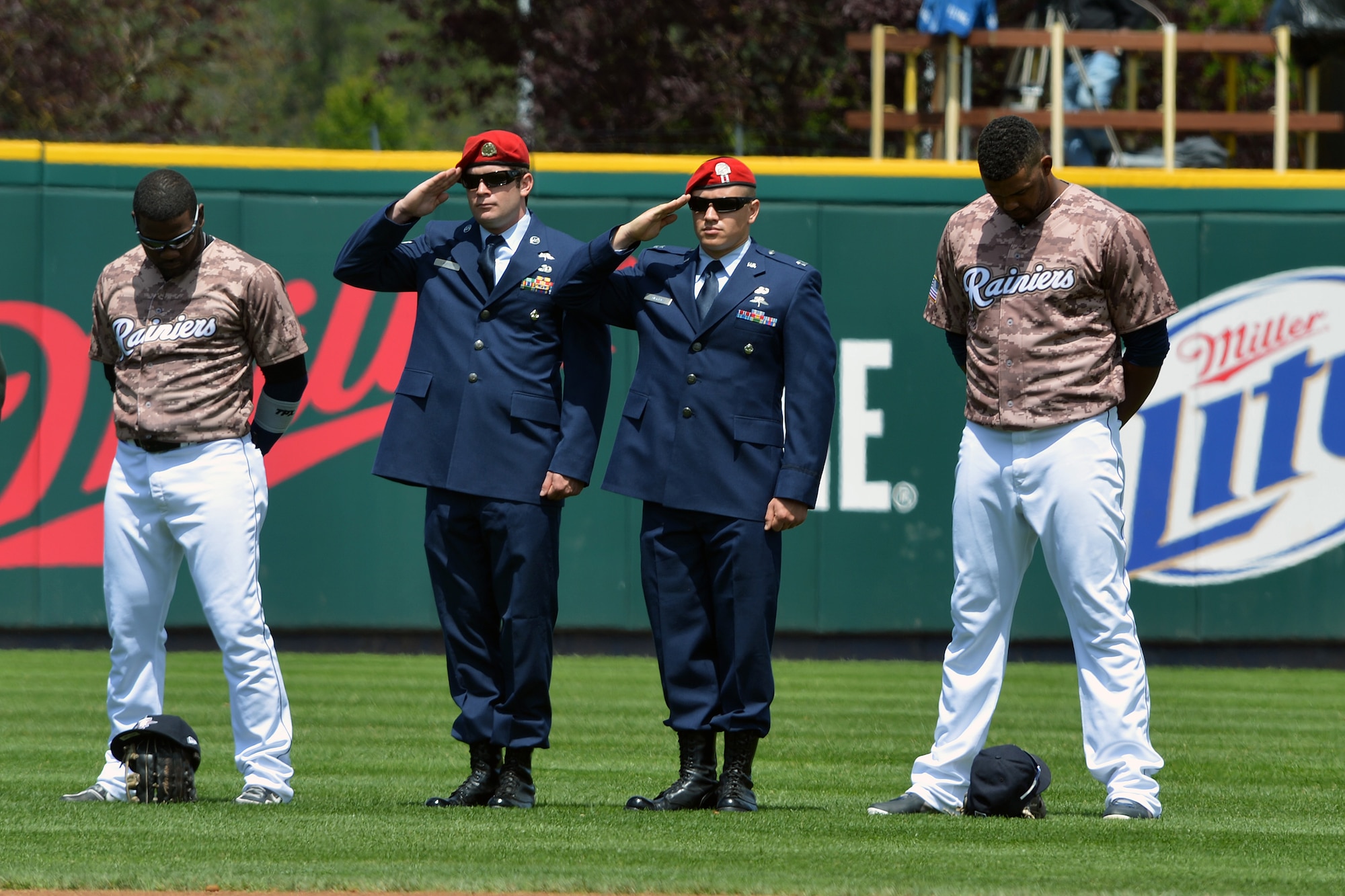 Senior Airman Mathew Laursen (center left), 22nd Special Tactics Squadron combat controller, and Capt. Jack Ambridge (center right), 22nd STS special tactics officer, from Joint Base Lewis-McChord, Wash., salute as the national anthem is played June 9, 2013 at the Tacoma Rainiers Salute to Armed Forces game in Tacoma, Wash. Tacoma Rainers players wore camouflage-patterned jerseys to honor men and woman serving in the U.S. armed forces. (U.S. Air Force photo/ Airman 1st Jacob Jimenez)