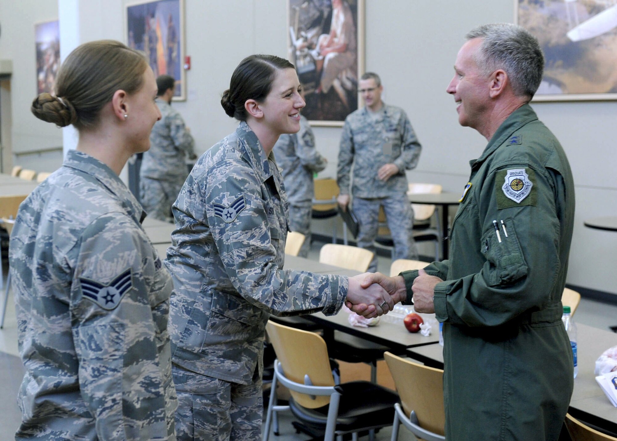 Maj. Gen. Bill Binger, 10th Air Force commander, shakes hands with Senior Airman Laura Soper, 71st IS, during his recent visit to the group as Senior Airman Leslie Brown, 71st IS, stands listens in to her left. (U.S. Air Force photo/ Staff Sgt. Michael J. Veloz)