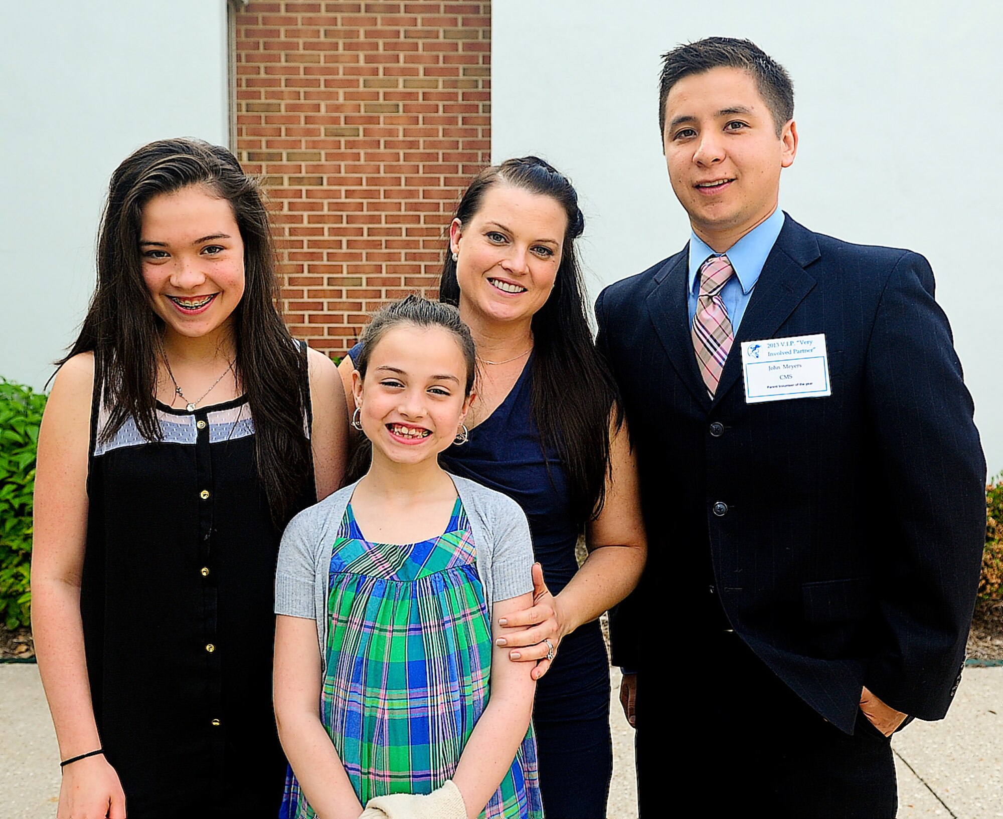 Staff Sgt. Jon Meyers, 9th Airlift Squadron flight engineer, poses with his wife Tricia, 436th Dental Squadron certified dental assistant, and his two daughters Hayleigh and Julena May 29, 2013, at Dover High School in Dover, Del. Meyers won the Capital School District Parent Volunteer of the Year award for Central Middle School for his 500 volunteer hours. (U.S. Air Force photo/Airman 1st Class Ashlin Federick)
