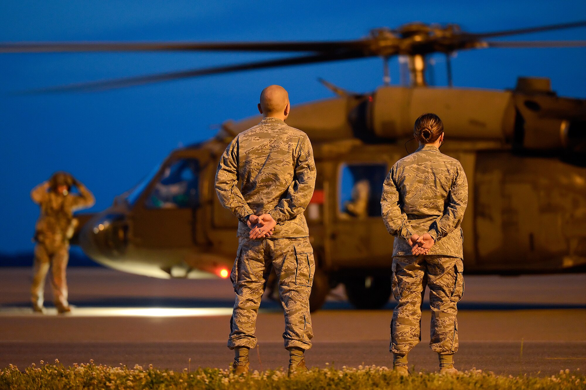 2nd Lt. Christopher Trejo (left) and 1st Lt. Amanda Davis, both from the 436th Airlift Wing Protocol Office, stand at parade rest while a U.S. Army UH-60A Blackhawk arrives June 2, 2013, at Dover Air Force Base, Del.  Dover AFB’s protocol office meets dignitaries who visit Dover for important events such as dignified transfers and official meetings. (U.S. Air Force photo/Greg L. Davis)
