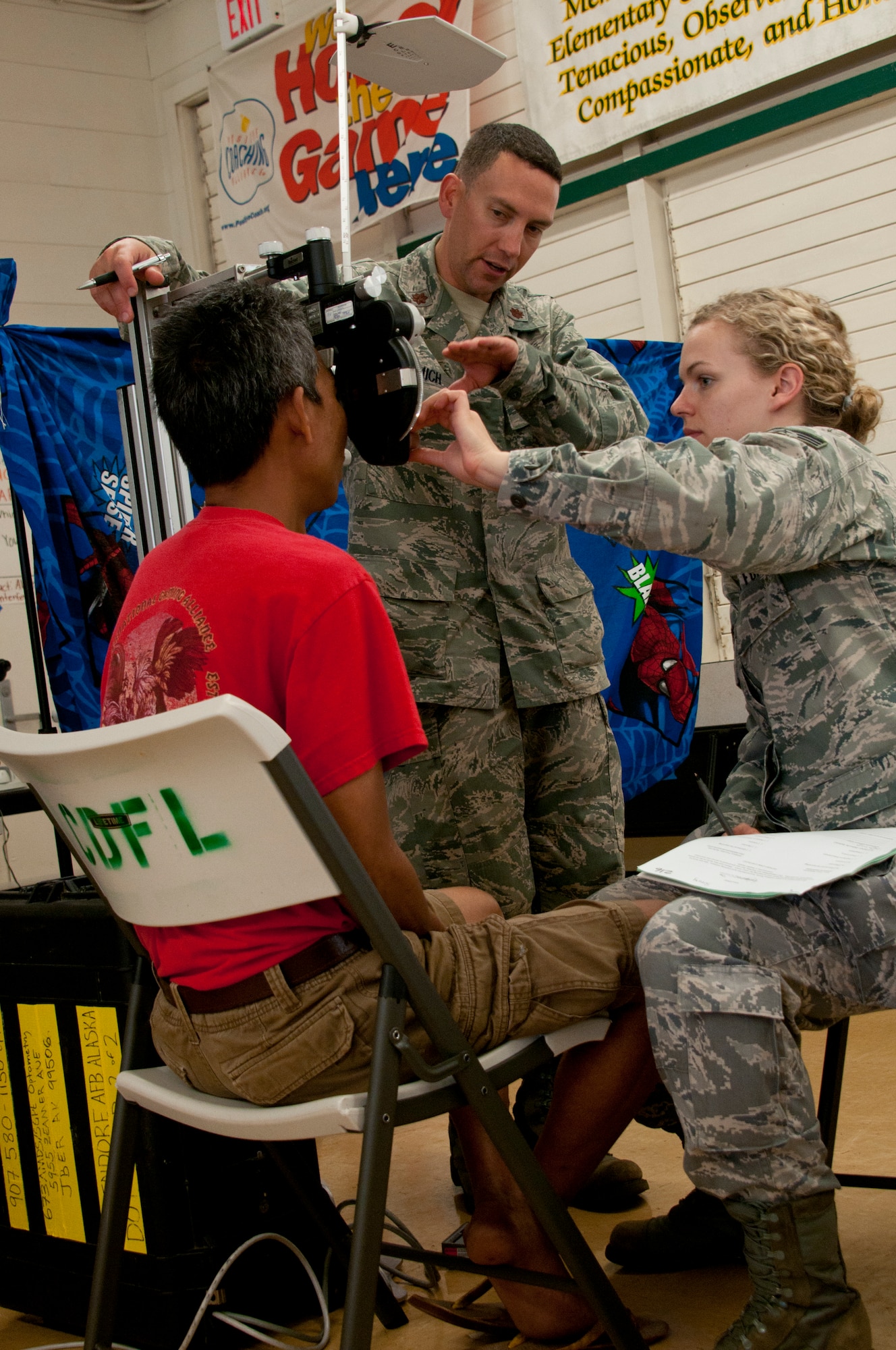 LANAI, Hawaii - Maj. Andrew Adamich, an optometrist from the 176 Medical Group, mentors Staff Sgt. Katherine Burrows, an optometry technician from the 151st Medical Group, June 5, 2013, here. Forty-five Alaska military personnel from Air and Army National Guard and active-duty Air Force traveled to set up and run medical clinics for medically-underserved Hawaiians on the islands of Lanai and Maui as part of an Innovative Readiness Training project June 2 to 14. The group joined about 500 other military personnel from multiple components of the Air Force, Army and Navy on four Hawaiian Islands at six sites as a joint training mission called TROPIC CARE 2013 – the largest IRT mission since the program began. National Guard photo by Staff Sgt. N. Alicia Goldberger.