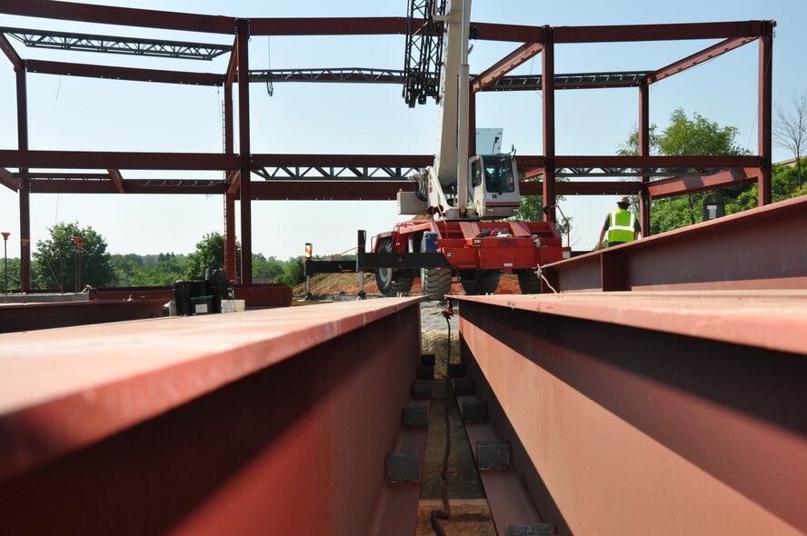 A contractor heads over to a crane staged on the site of the future Navy Operational Support Center-Pittsburgh, June 3, 2013 at the Pittsburgh International Airport Air Reserve Station. Steel beams began going up the week of May 28, which put the project at the 25% completion phase.   To date, all site utility work has been completed and the footings have all been poured. This along with the other site work has kept the project on target for its Spring 2014 delivery. 