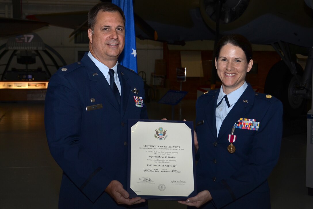 Maj. Kathryn Fiddler, 512th Airlift Wing equal opportunity officer, receives her certificate of retirement from Lt. Col. Andrew Eiler, 512th Operations Support Flight commander, during her retirement ceremony at the Air Mobility Command Museum, Dover, Del., June 9, 2013. Fiddler, a 26-year Air Force veteran, began her Air Force career as an enlisted radar intelligence technician before receiving a commission in the U.S. Navy and then later transferring to the AF Reserve. (U.S. Air Force photo/Senior Airman Joseph Yanik) 