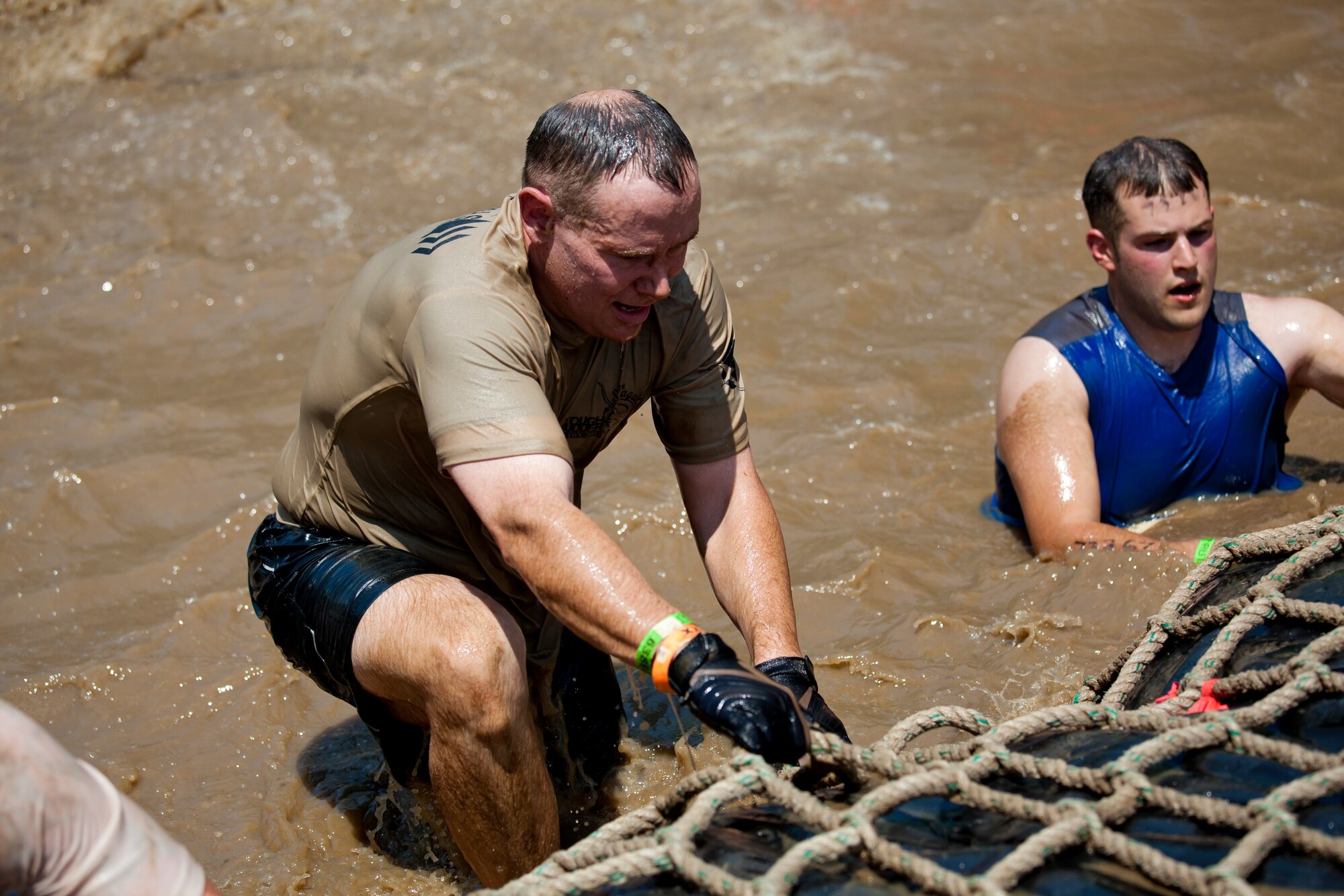 Col. Patrick Cobb, 102nd Intelligence Wing Commander, climbs out of the “Firewalker” obstacle in Gilford, N.H. on June 1, 2013. Twenty-eight members of the 102nd Intelligence Wing challenged themselves by completing the Boston Tough Mudder event. (National Guard photo by Staff Sgt. Jeremy Bowcock/Released)