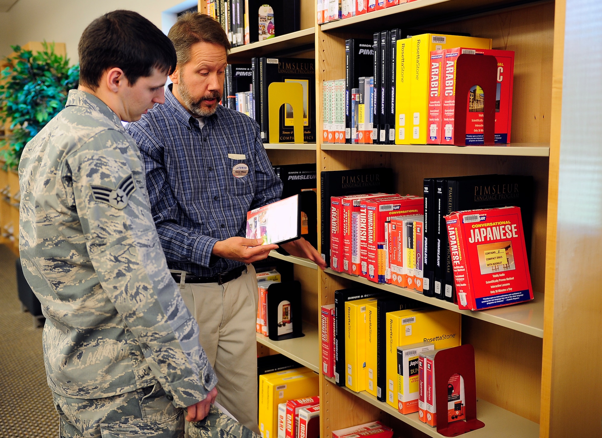 Senior Airman Matthew King, 509th Communications Squadron intrusion detection technician, learns about the different programs available for learning Japanese from Dennis Wilson, 509th Force Support Squadron supervisory librarian, at the library at Whiteman Air Force Base, Mo., May 23, 2013. The library offers many different programs and materials to help individuals learn foreign languages. (U.S. Air Force photo by Airman 1st Class Shelby R. Orozco/Released)