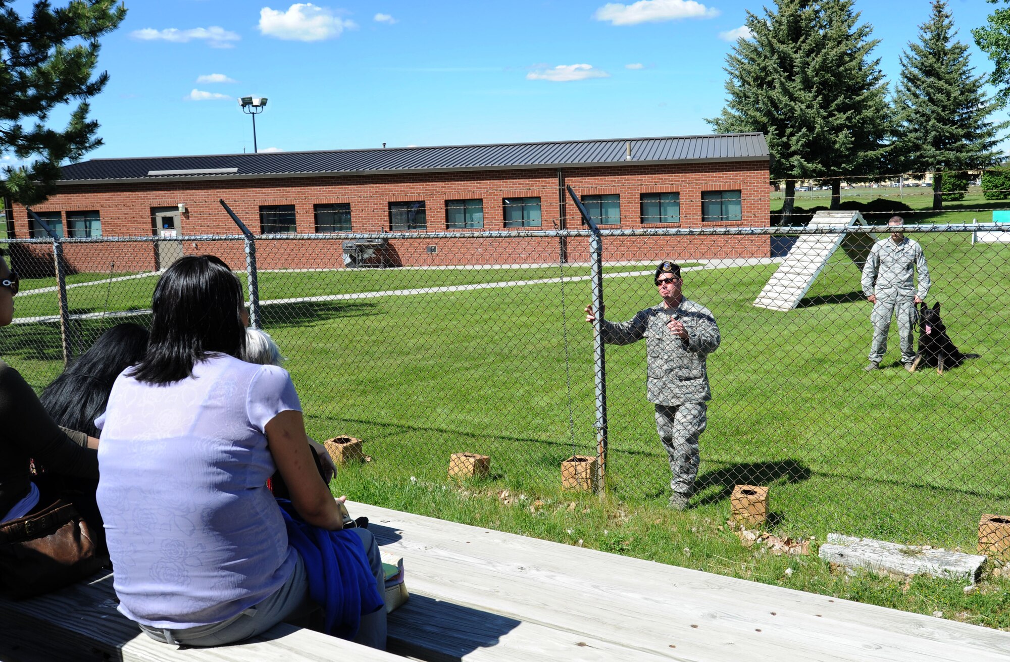 Tech. Sgt. Levi Wilson, 92nd Security Forces Squadron Military Working Dog kennel master, explains what MWD are all about during a tour for the Society of American Indian Government Employees at Fairchild Air Force Base, Wash., June 4, 2013. SAIGE students visited Spokane for a conference which included a tour of the base. (U.S. Air Force photo by Airman 1st Class Janelle Patiño/Released)