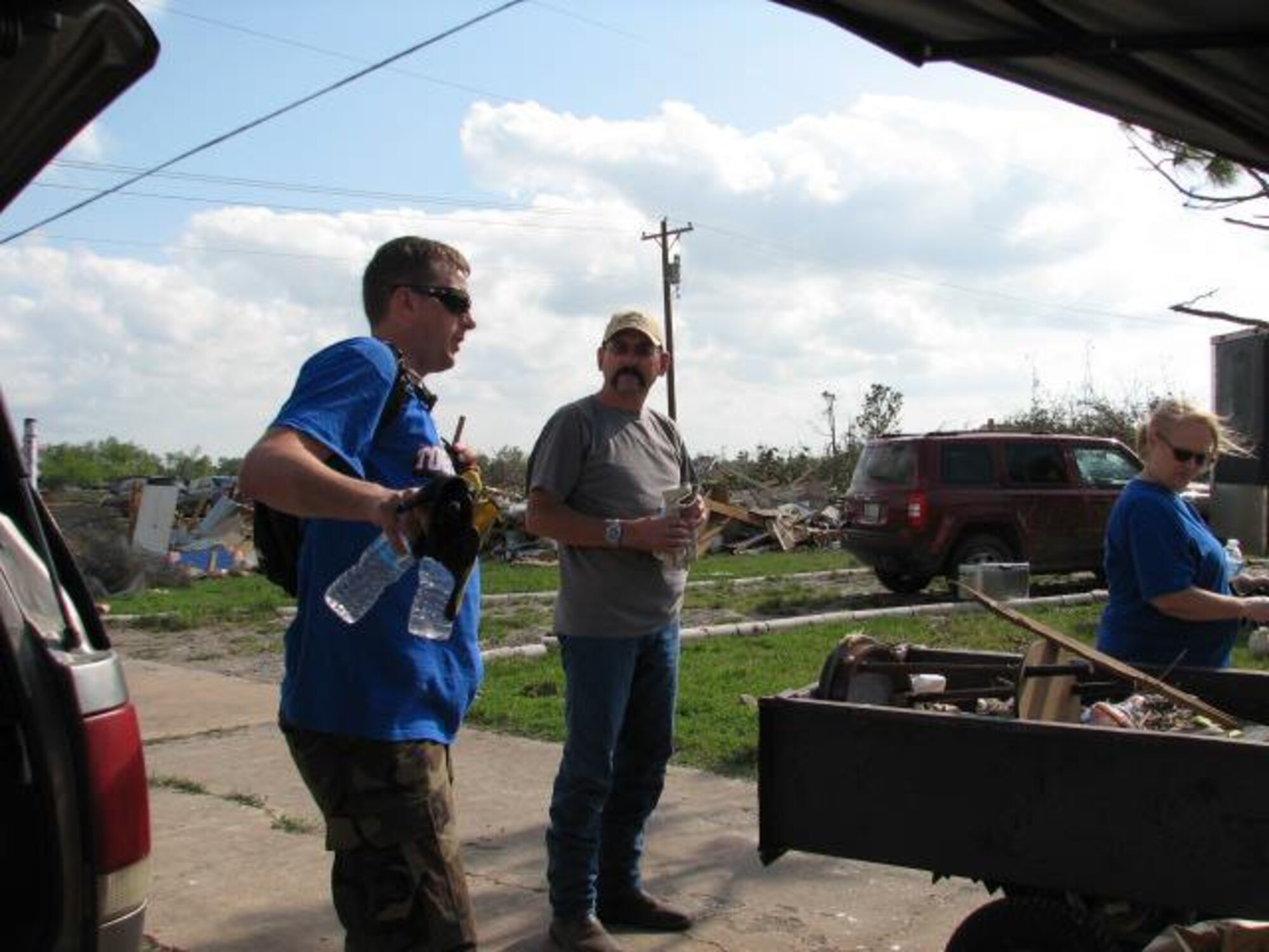 Master Sgt. Derick Heflin, 342nd Recruiting Squadron health professions recruiter, (left) helps Steve and Becky McClellam, relatives of tornado victims in Del City, Okla., sort through a damaged home Memorial Day weekend. (Courtesy photo)