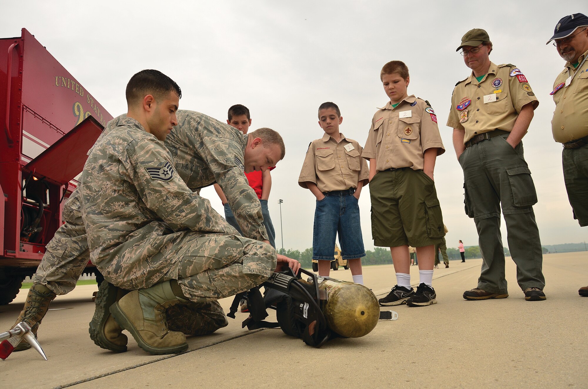 WRIGHT-PATTERSON AIR FORCE BASE, Ohio - From left to right; Staff Sgts. Hugh Gibbs and Brian Sparks, Jr., both firefighters from the 445th Civil Engineer Squadron, show a fire fighter oxygen tank to a group of Scouts as part of the 445th Airlift WIng's annual Scouts Day May 18. (U.S. Air Force photo/Staff Sgt. Mikhail Berlin)