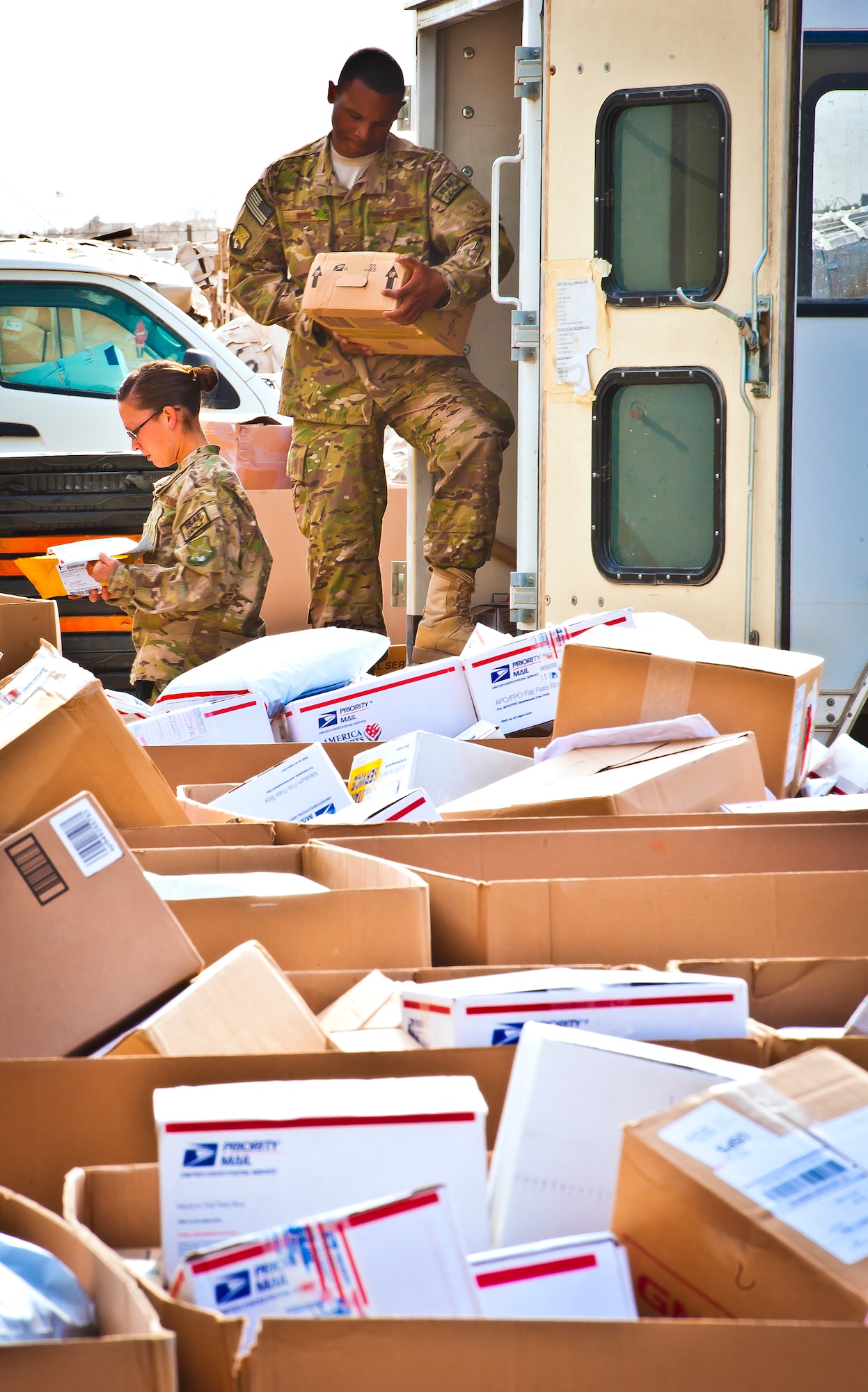 U.S. Air Force Staff Sgt. Hollie Darling and Senior Airman Ken Wise separate mail according to its final destination at Kandahar Airfield, Afghanistan, May 10, 2013. On average, the mail crews handle more than 50,000 pounds of mail a week. During the holiday season, roughly 130,000 pounds of mail is distributed weekly. (U.S. Air Force/photo Senior Airman Scott Saldukas)