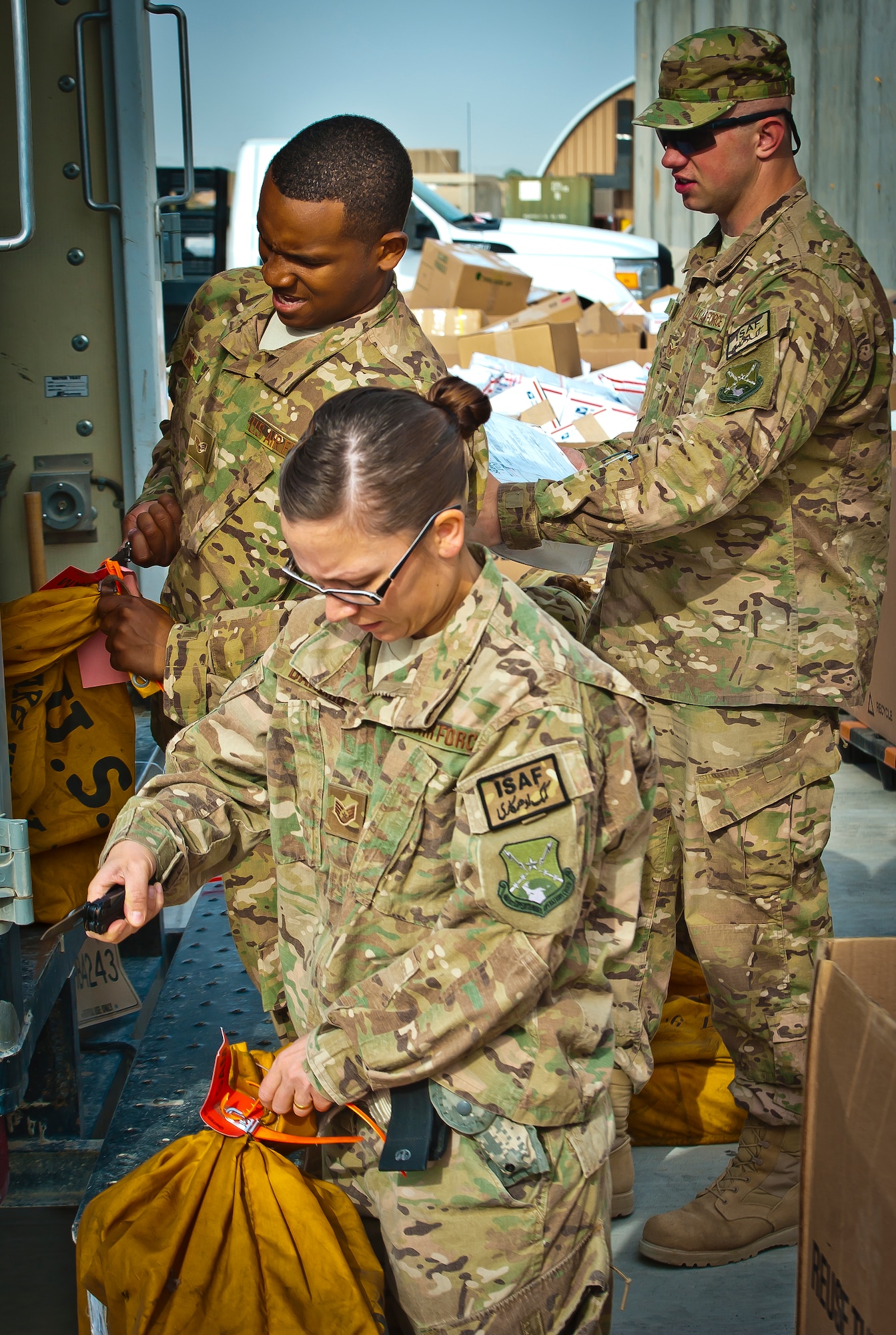(Front to back) U.S. Air Force Staff Sgt. Hollie Darling, Senior Airman Ken Wise and Staff Sgt. Joshua McMillian separate mail according to its final destination at Kandahar Airfield, Afghanistan, May 10, 2013. On average, the mail crews handle more than 50,000 pounds of mail a week, increasing to approximately 130,000 pounds of mail weekly during the holiday season. (U.S. Air Force/photo Senior Airman Scott Saldukas)