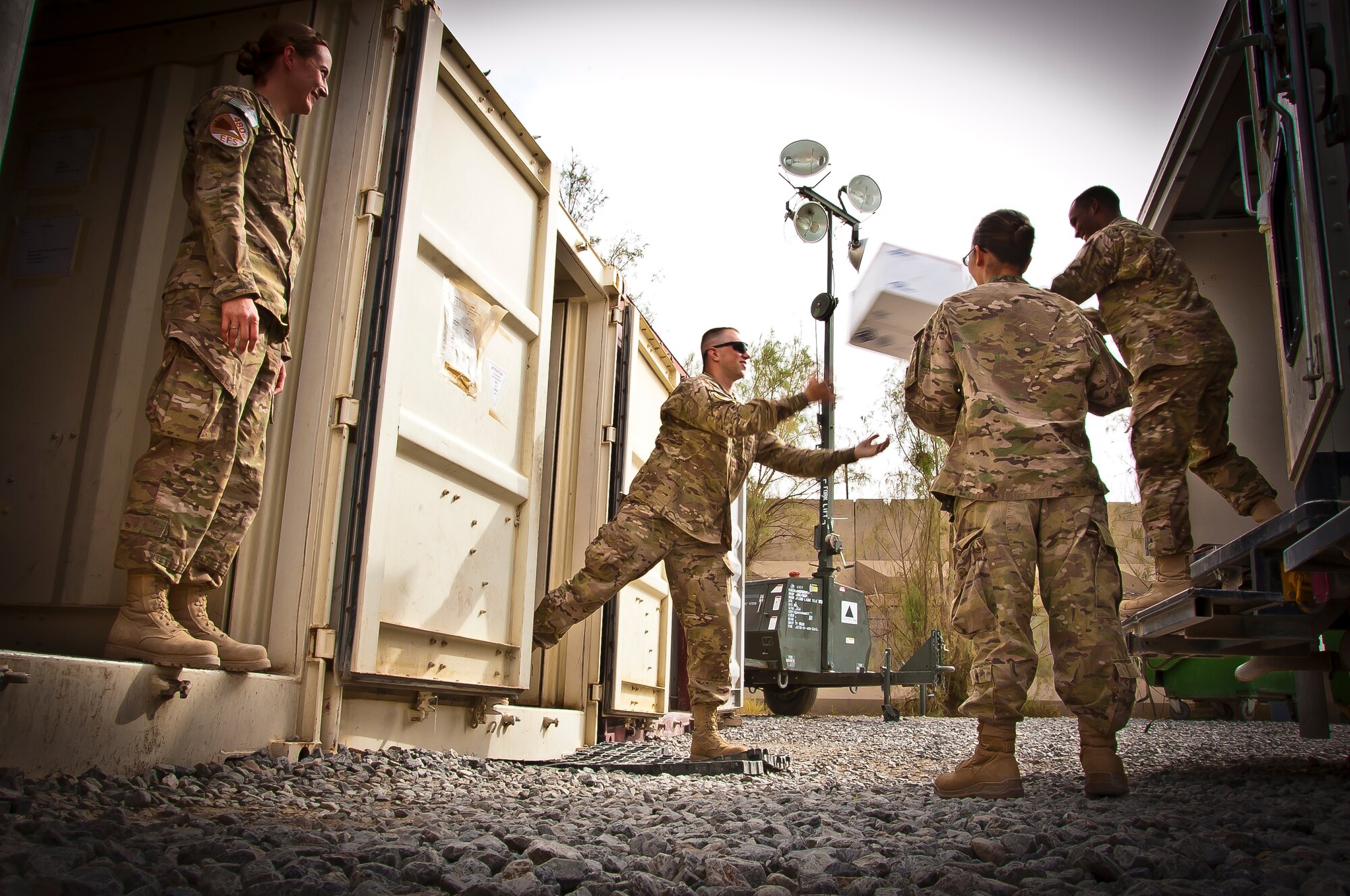 U.S. Air Force Senior Airman Ken Wise, 451st Air Expeditionary Wing mail custodian, tosses a package to U.S. Air Force Staff Sgt. Joshua McMillian, 480th Expeditionary Fighter Squadron and mail crew volunteer, at Kandahar Airfield, Afghanistan, May 10, 2013. Members from different squadrons within the wing assist the mail custodian to gather, sort and distribute mail amongst Air Force personnel. (U.S. Air Force/photo Senior Airman Scott Saldukas)