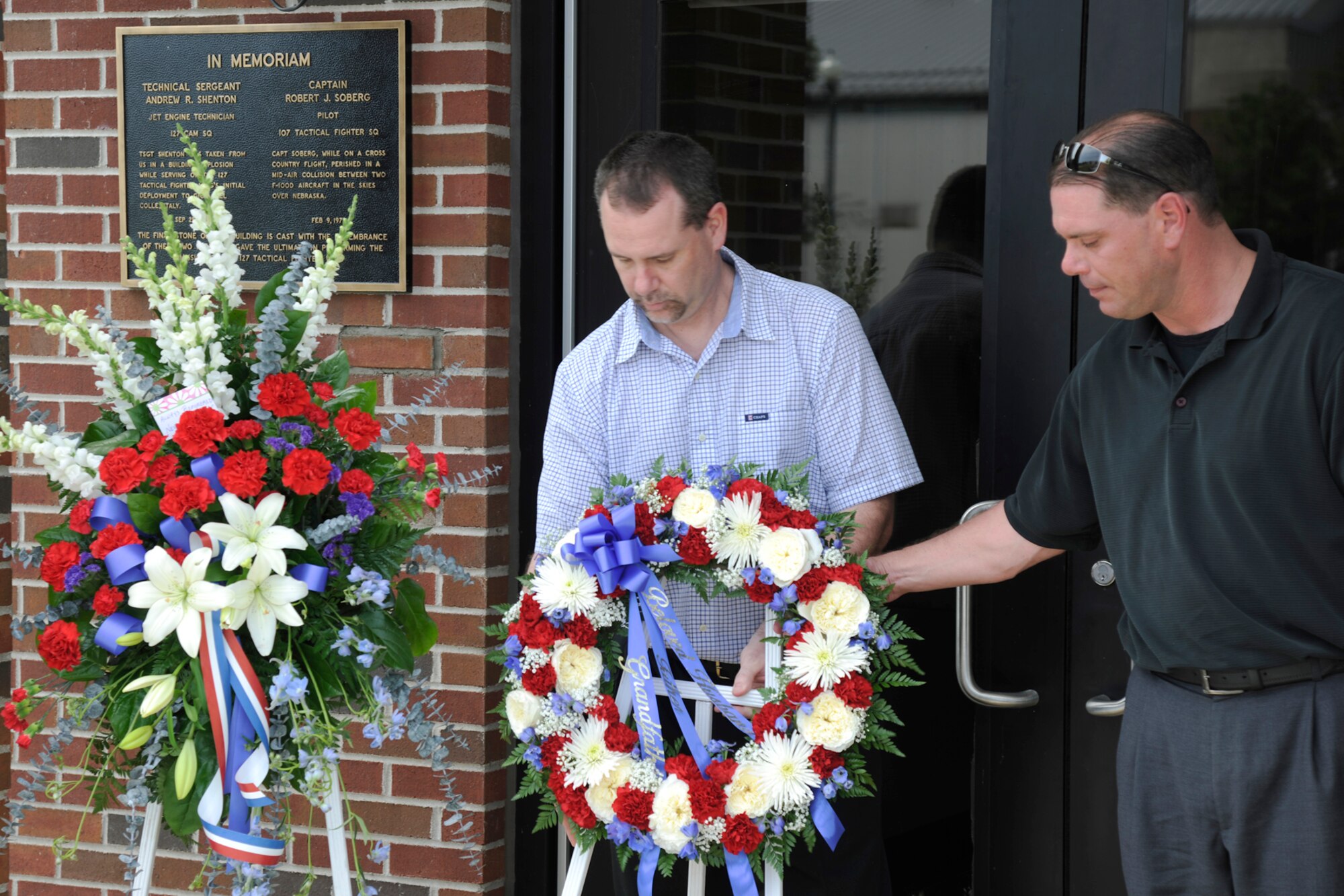 130609-Z-EZ686-042 -- Greg and Terry Shenton place a wreath outside the main entrance to the 127th Operations Group Building on Selfridge Air National Guard Base, Mich., June 9, 2013. Their father, Technical Sgt. Andrew R. Shenton, was killed  when the building he was working in exploded while he deployed to Italy as an aircraft engine mechanic with the 127th on Sept. 25, 1981. The Ops Building is dedicated to Shenton and to Capt. Robert J. Soderberg, a pilot who was killed in a crash of an F-100 Super Sabre on Feb. 9, 1979. (U.S. Air Natonal Guard photo by TSgt. Dave Kujawa / Released)