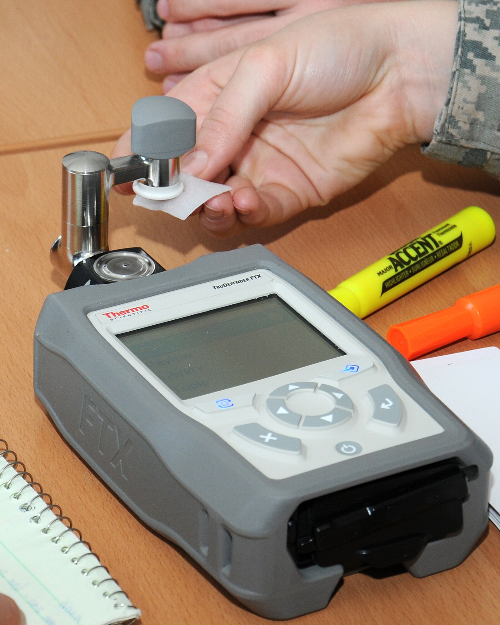 Airman 1st Class Breanna Wallace, 100th Civil Engineer Squadron Emergency Management apprentice from Lostine, Ore., uses an alcohol swab to clean a handheld chemical and explosives identification tool during a hazardous materials hands-on training class June 6, 2013, at RAF Mildenhall, England. Service members were taught how to properly use the machine to ensure an accurate reading. The two-day training ensured RAF Mildenhall first responders and emergency responders are better equipped to quickly and effectively mitigate a hazardous material incident. (U.S. Air Force photo by Gina Randall/Released)