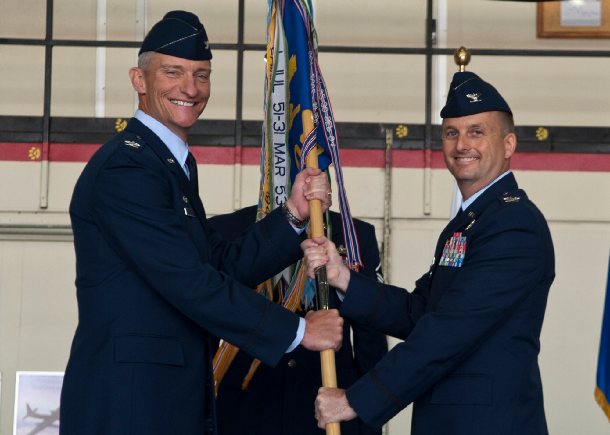 Col. Patrick McKenzie, 51st Fighter Wing commander, passes the 51st Operations Group guidon to Col. James Clark, incoming 51st OG commander, during the 51st OG change of command ceremony at Osan Air Base, Republic of Korea, June 7, 2013. As the new 51st OG commander, Clark will lead more than 265 personnel and direct operations for A-10 Thunderbolts, F-16 Fighting Falcons and operations support squadrons. (U.S. Air Force photo/Senior Airman Siuta B. Ika)