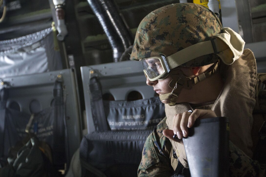 Marine Corps Lance Cpl. David Anzualda, a cyber network operator with the 26th Marine Expeditionary Unit command element, peers out the back of an MV-22B Osprey as he crosses decks from the USS Bataan to the USS San Antonio, Dec. 15, 2012. This was part of the 26th MEU's third major training exercise of their pre-deployment training process. The 26th MEU operates continuously around the globe, providing a forward-deployed, sea-based quick-reaction force. The MEU is a Marine air-ground task force capable of conducting amphibious operations, crisis response and limited contingency operations. U.S. Marine Corps photo by Cpl. Kyle N. Runnels