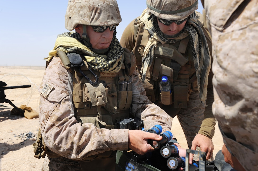 U.S. Navy Petty Officer 2nd Class Matthew Dunkle, left, loads training rounds into an MK19 40mm grenade launcher while participating in marksmanship training on Camp Leatherneck, Helmand province, Afghanistan, June 1, 2013. Dunkle, a construction mechanic, is assigned to Naval Mobile Construction Battalion 15's convoy security element.