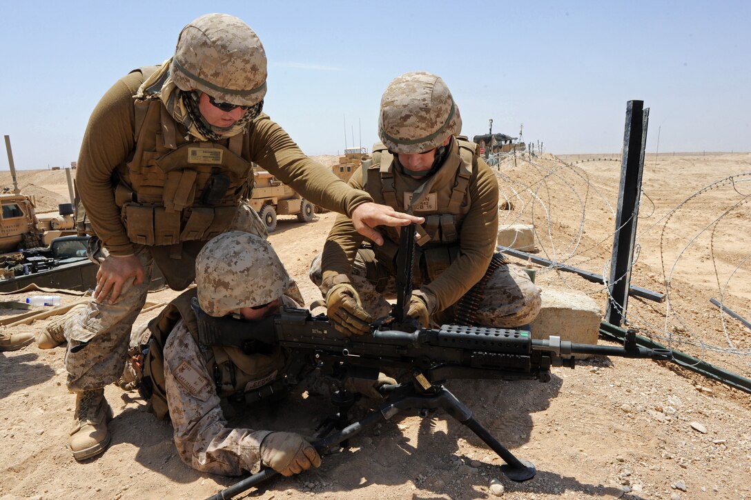U.S. Navy Seaman Jeffrey Dimon, right, helps U.S. Navy Petty Officer 1st Class Baltazar Perez, center, load ammo into an M-240B machine gun while participating in marksmanship training on Camp Leatherneck, Helmand province, Afghanistan, June 1, 2013. Dimon, a construction mechanic, and Perez, a builder, are assigned to Naval Mobile Construction Battalion 15's convoy security element.