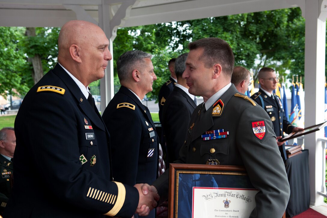 Army Chief of Staff Gen. Ray Odierno, left, shakes hands with Austrian army Col. Rudolf Zauner during the Army War College's graduation ceremony for the Class of 2013 in Carlisle Barracks, Pa. June 8, 2013. Zauner won the Commandant’s Award for Distinction in Research for his essay: “Cooperation and Integration: Keeping Austria’s Forces Relevant for 21st Century.”
