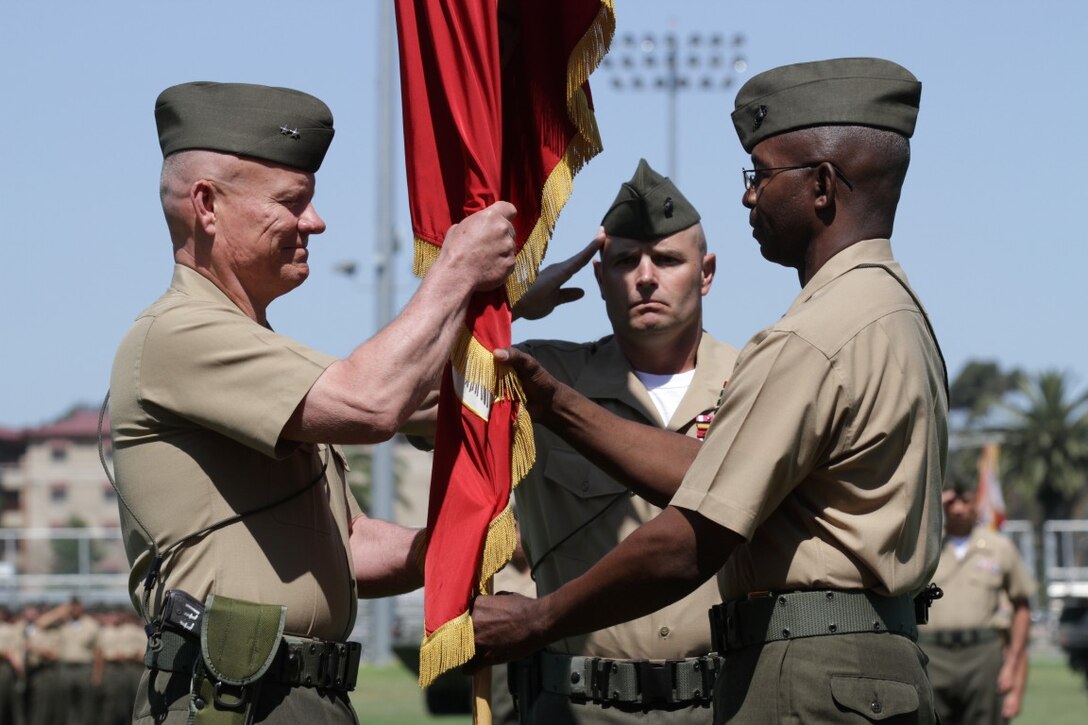 Major General Lawrence D. Nicholson (left), the new commanding general of 1st Marine Division and Maj. Gen. Ronald L. Bailey, the former commanding general of 1st Marine Division, exchanges the division's colors during a change of command ceremony here, June 9, 2013. Major Gen. Nicholson, a native of Toronto, Canada, served as the operations officer for the International Security Assistance Forces in Kabul, Afghanistan, before assuming command of the division.