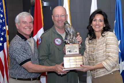 Gen. Gene Renuart, center, commander of North American Aerospace Defense Command and U.S. Northern Command, and Kirk Brown, NORAD and USNORTHCOM Combined Federal Campaign chairperson, accept the CFC Regional Excellence Award from Pikes Peak CFC Regional Director Barbara Fitz during a ceremony at command headquarters Jan. 7, 2008. The commands earned the award by increasing their percentage of participants more than any other agency in the region's 2007 Combined Federal Campaign. The commands also raised five thousand dollars more than their goal of $203,000. Directorates in the commands received 14 gold, one silver and one bronze award for their CFC donations, and Brown and Air Force Capt. Mark Walker both received CFC Hero Awards. Brown also was designated as the CFC Regional Civilian Hero and is now eligible for national recognition. During the same time period as CFC, Canadian servicemembers in NORAD raised $21,000 for the Canadian National Defence Workplace Charitable Campaign. 