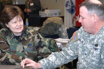 Brig. Gen. Frances Auclair, Maine National Guard chief of staff, and Col. Mark Lovejoy, Vermont National Guard director of Force Structure, Resources and Assessment, discuss a briefing at the Joint Task Force Commander Training Course Jan. 29, 2008, at U.S. Nothern Command headquarters at Peterson Air Force Base, Colo. USNORTHCOM conducts the four-day course twice each year for Army and Air National Guard senior officers who have been nominated by their state adjutants general as potential joint task force commanders. The course presents attendees with a compilation of current policy, directives, guidance and lessons learned regarding the command of a joint task force in the United States and prepares the officers to effectively operate in situations requiring the mobilization of National Guard and active-duty forces. 